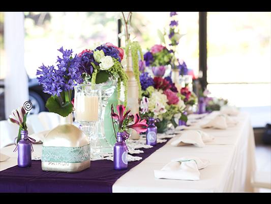 view of banquet seating with ornate blue, white and pink flower centerpieces