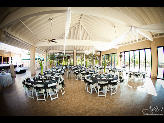 Sunny view of banquet center with dark table tops and chair accents